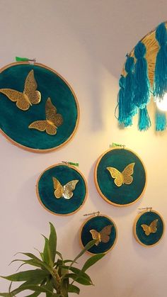 the wall is decorated with gold butterflies and tassels on green velvet, along with a potted plant