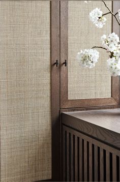 a vase filled with white flowers sitting on top of a wooden table next to a window