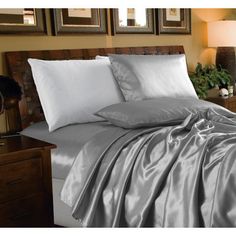 a bed covered in silver sheets and pillows