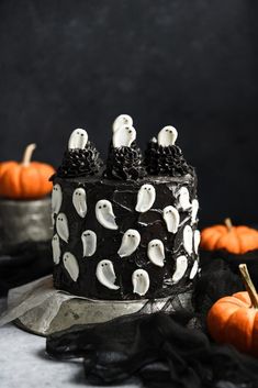 a black cake with white ghost decorations on it