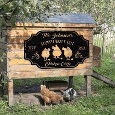 the chickens are standing in front of the sign for the farm's pulled putt up chicken coop