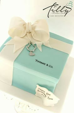 a blue box with a white bow and necklace on it that says tiffany & co