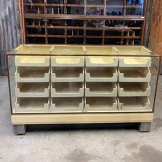 an old dresser with lots of drawers on it's sides and some shelves in the background