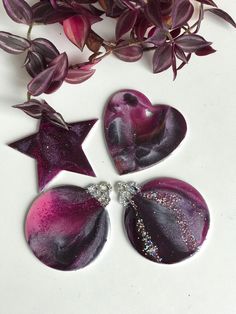 three purple hearts and two star shaped brooches