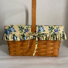 a basket that has flowers on it with a yellow and blue flowered lining around the edge