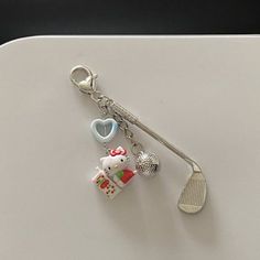 a keychain with a hello kitty charm hanging from it's side on a table