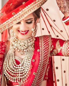 a woman wearing a red and gold bridal outfit