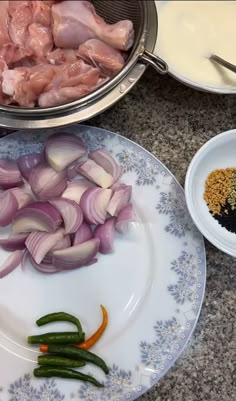 onions, green beans and other ingredients on a plate next to a pan with chicken