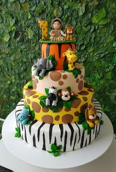 a multi layer cake decorated with animals and giraffes