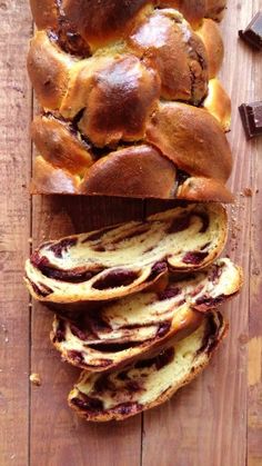 a loaf of bread sitting on top of a wooden table next to some chocolate bars