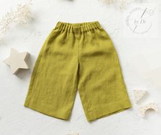 a child's green pants with buttons on the side and stars in the background