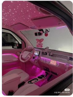 the interior of a car with pink lights and decorations on the ceiling, along with remote controls