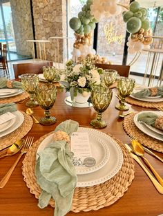 the table is set with plates, silverware and gold utensils on it