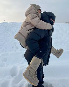 a man carrying a woman on his back in the snow