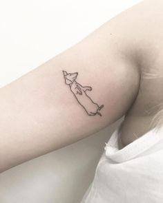 a woman's arm with a small tattoo of a dog on the left side