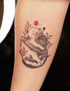 a tattoo on the arm of a woman with a cat hugging it's back