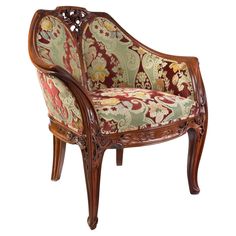 an ornate wooden chair with floral upholstered fabric on the armrests and back