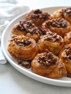 a white plate topped with cinnamon rolls on top of a table