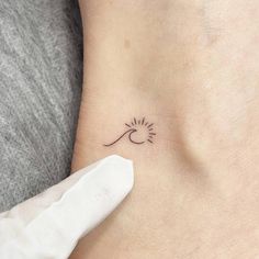 a small sun and wave tattoo on the ankle