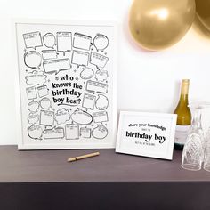 a birthday card and wine glasses on a table with balloons in the background, along with a bottle of champagne