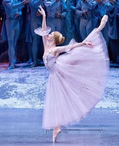 a ballerina is performing in front of a group of dancers