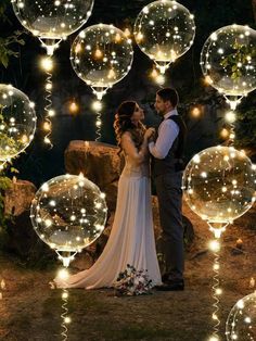 a bride and groom standing in front of giant bubbles that are floating down the air