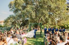 a bride and groom standing under a tree at their wedding ceremony