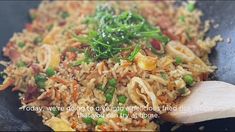 rice and vegetables being cooked in a wok