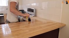 a man is sanding the counter top with a sandpaper roller in his hand