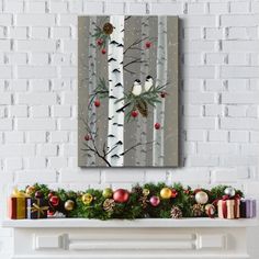 a painting on the wall above a fireplace with christmas decorations and presents in front of it