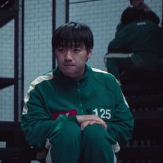 a young man sitting on top of a wooden bench