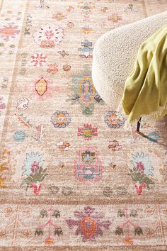 an area rug with various colors and designs on the floor, including pinks, oranges, yellows, and green