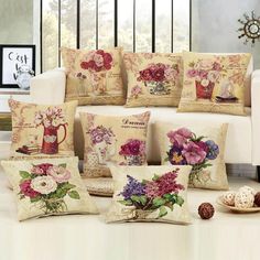 pillows with flowers on them sitting in front of a white couch