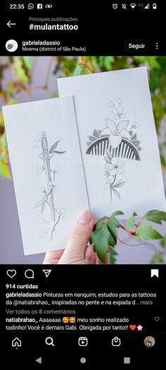 someone is holding up two cards with drawings on them, and the other one has a leaf in it