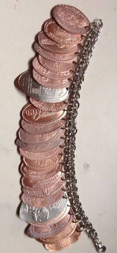 a bunch of coins that are sitting on a white surface with chains attached to them