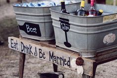 two buckets filled with wine sitting on top of a wooden table next to each other