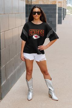 Every day is game day with our Kansas City Chiefs short sleeve rhinestone fringe tee with ribbed neckline. From the game to the everyday, this is your go-to choice. Trendy Short Sleeve T-shirt With Fringe, Trendy Short Sleeve Fringe T-shirt, Casual Short Sleeve Fringe T-shirt, Trendy Fringe Short Sleeve T-shirt, Casual Crew Neck T-shirt With Fringe, Black T-shirt For Game Day In Summer, Fringe Tee, Rhinestone Fringe, Ribbed Neckline