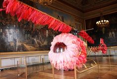 a large piece of art that looks like an eyeball with feathers hanging from it