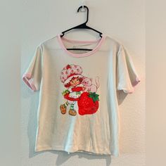 Bnwot Strawberry Shortcake Shirt. Open For Offers! :) Sweet White Tops With Strawberry Print, Cute Strawberry Print Shirt, Sweet White Cotton T-shirt, Sweet Short Sleeve Cotton Shirt, Cute Strawberry Print Crew Neck Shirt, Cute Crew Neck Shirt With Strawberry Print, Retro Cotton Top With Strawberry Print, Vintage Strawberry Print Crew Neck Top, Vintage Crew Neck Top With Strawberry Print