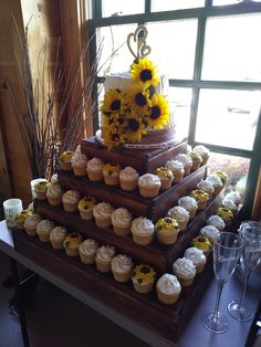 a cake with sunflowers and cupcakes on it