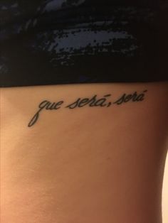 a woman's lower back tattoo with the words gue seba, sera written in cursive font