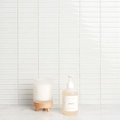 a soap dispenser next to a bottle of liquid on a marble counter