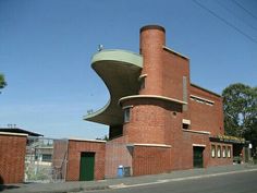 the building is made of red bricks and has a curved design on it's side