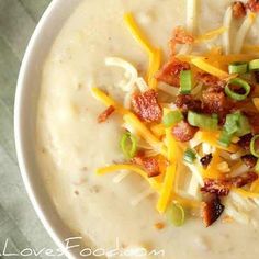 a white bowl filled with soup topped with cheese and bacon