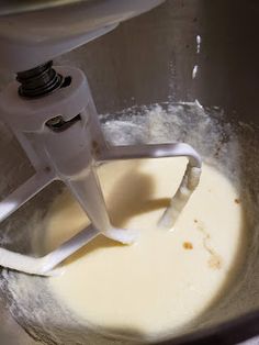 a blender filled with white batter in a silver bowl on top of a counter