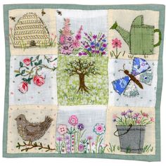 a patchwork quilt with flowers, birds and watering can on the front is shown