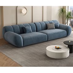 a blue couch sitting on top of a gray rug next to a white coffee table