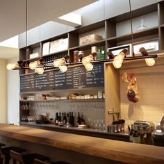 a bar with several lights hanging from the ceiling