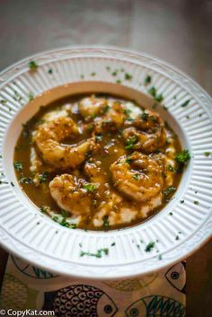 a white bowl filled with shrimp and gravy