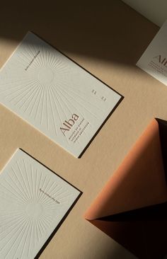 two business cards on top of each other next to an envelope with the word aiga printed on it